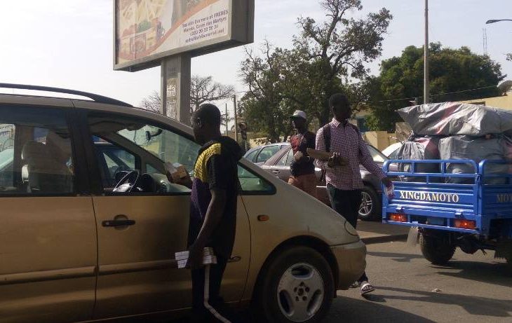 Commerce ambulant dans la circulation : des jeunes se frottent les mains